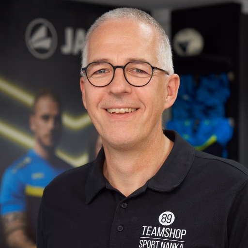Portrait of a smiling customer testimonial speaker wearing a TEAMSHOP shirt.